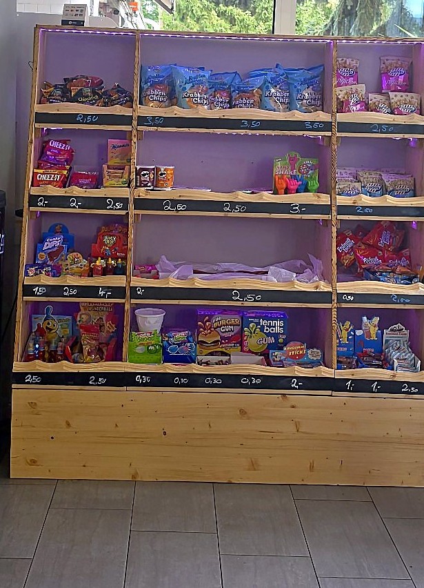 Süßigkeiten-Regal mit Chips, Kaugummi und bunten Naschereien
