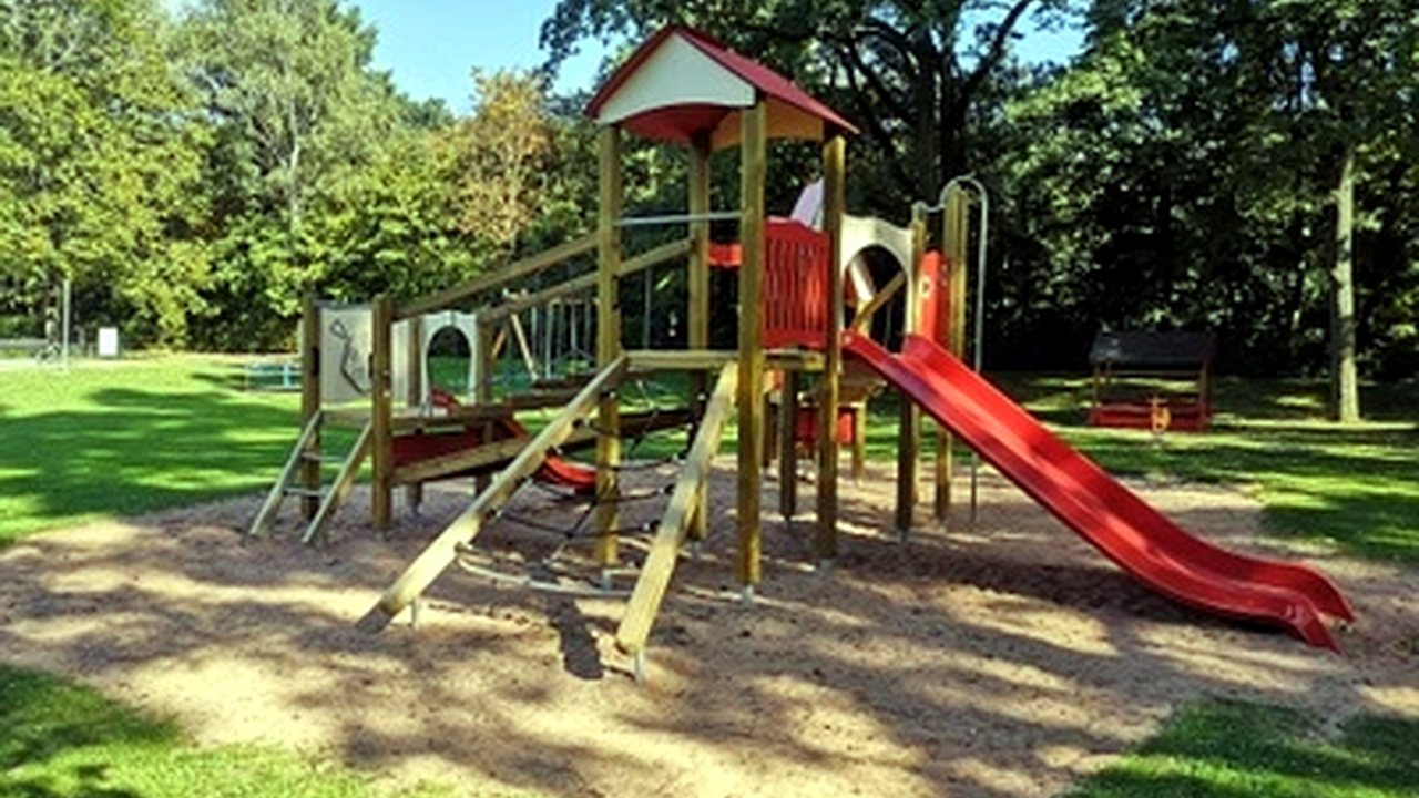 Großer Spielplatz mit Kletterturm und roter Rutsche im Clubbad